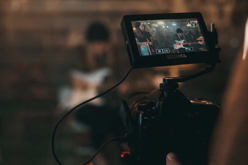 Persona grabando un vídeo profesional en un estudio moderno con luces de fondo