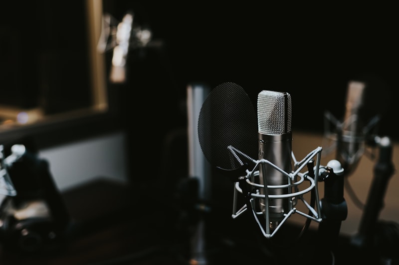 Persona grabando un podcast con micrófonos condensadores en estudio profesional